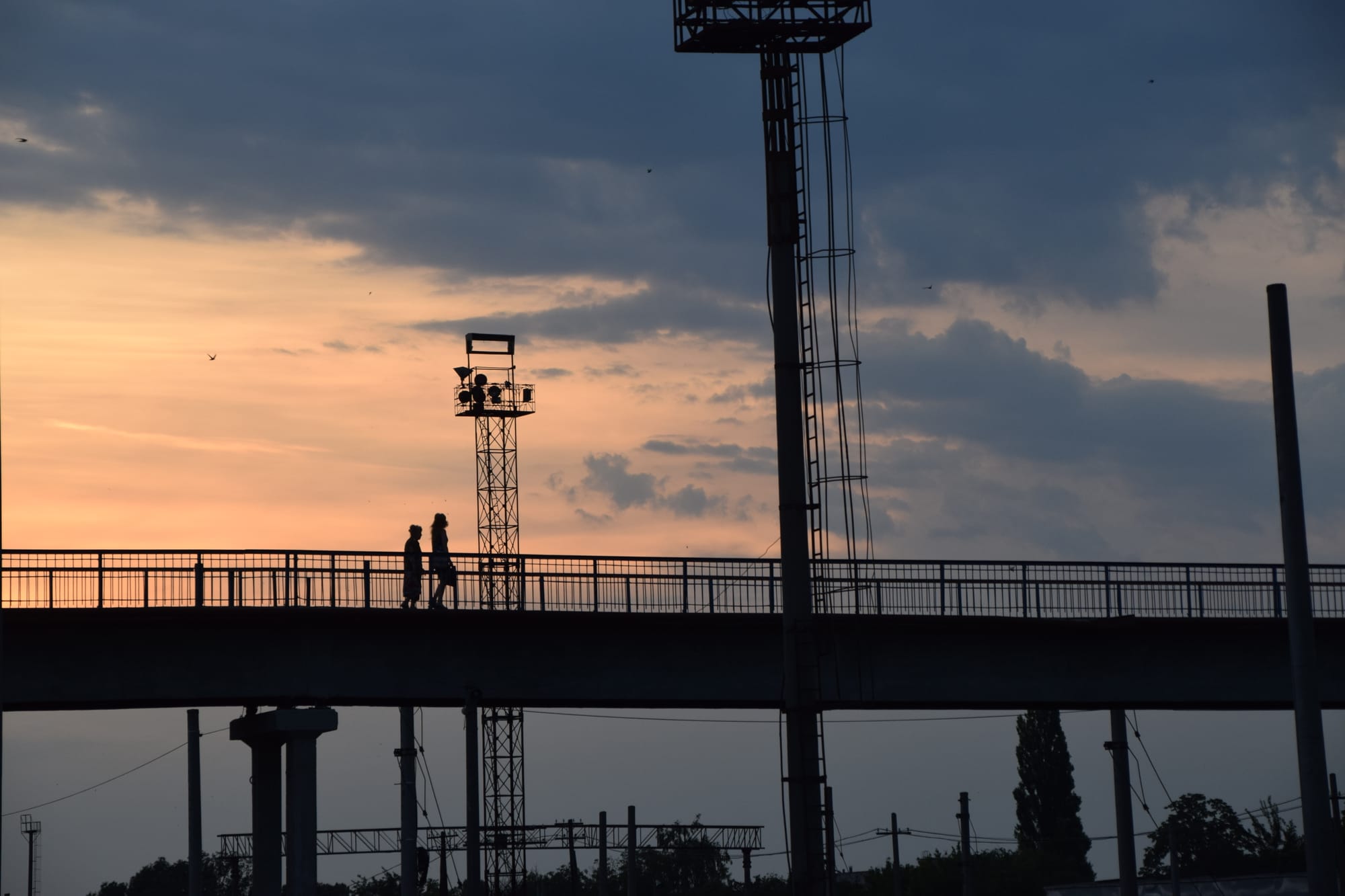 Pedestrians cross a footbridge at dusk in Tiraspol